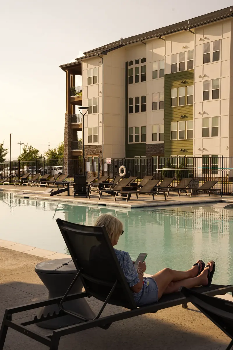 Resident relaxing on a lounge chair beside the resort-style pool at Fitzroy Grove
